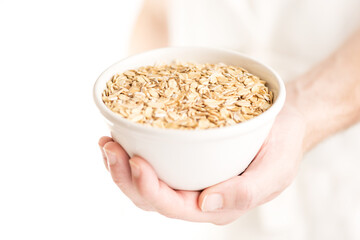 An oat flakes bowl held by a man hand