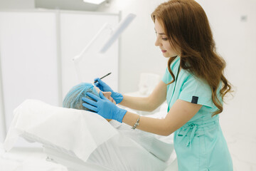 Hands of cosmetologist making preparation for face contouring plasty. Young woman gets beauty facial injections in salon. Aesthetic cosmetology