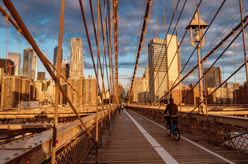 Bicyclist on Brooklyn Bridge during sunrise in New York. USA