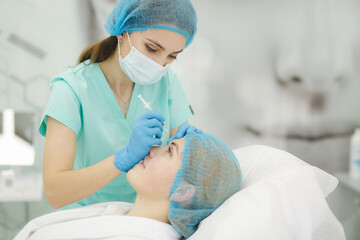 Woman getting injection. Beauty injections and cosmetology in beaty clinic. Cosmetologys in medical mask