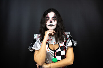 woman in a halloween clown costume over isolated black background thinking looking tired and bored with crossed arms