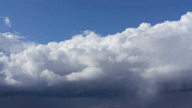 Tame lapse. Clouds transformation from white and fluffy to dark and stormy 
Big plump and fluffy clouds rising up to the clear blue sky and transform to stormy a rainy