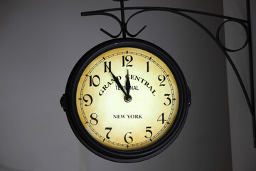 Large hanging clock showing five to twelve