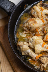 prepared chicken wings at frying pan on a wooden desk. domestic cooking