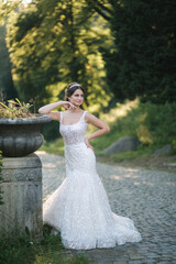 Fototapeta na wymiar Young female model in wedding dress outdoors. Fashion photo of bride