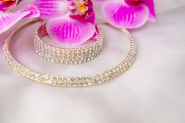 Bracelet and necklace on white fabric and purple Orchid
