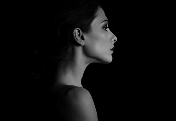 Beautiful woman with elegant healthy neck, nude back and shoulder on black background with empty...