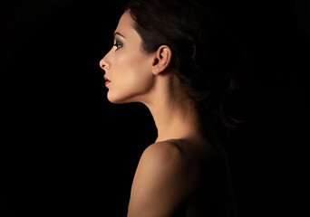 Beautiful makeup woman with elegant healthy neck, nude back and shoulder on black background with empty copy space. Closeup profile view portrait. Art.