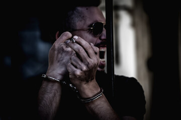 Portrait of handcuffed man imprisoned for crime, punished for serious villainy.  Pain, arrest,...