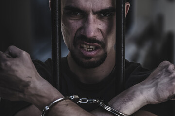 Portrait of aggressive handcuffed man. Arrest, gangster, pain concept.