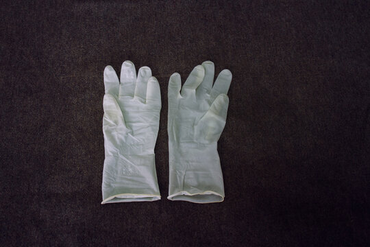 Top View Of White Plastic Gloves On A Dark Surface