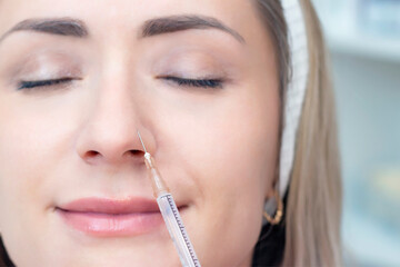 young woman receiving cosmetic injection of botox, close up. Woman in a beauty salon. Plastic Surgery Clinic.