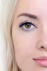 Fototapeta premium Eyelash extension procedure. Woman eye with long eyelashes. Close up. vertical photo