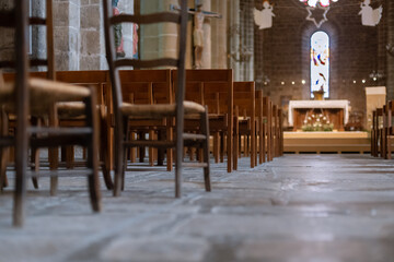 Row of wooden chairs inside a church in France.