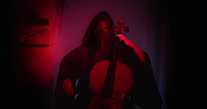 Black plague doctor playing the cello at home