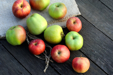 Delicious organic apples on a wooden desk covered with jute