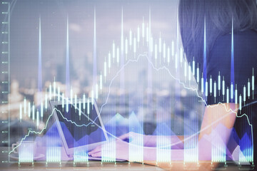 Double exposure of businesswoman hands typing on computer and forex chart hologram drawing. Financial analysis concept.