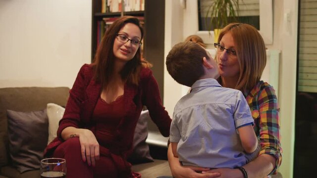 Mother and aunt playing with toddler boy in home party