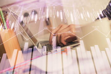 Double exposure of woman hands typing on computer and forex chart hologram drawing. Stock market...