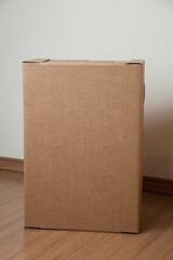 Cardboard box with order placed on the floor in an empty room with a neutral background. delivery concept. economy concept. business concept. shopping concept. copy space. Nobody