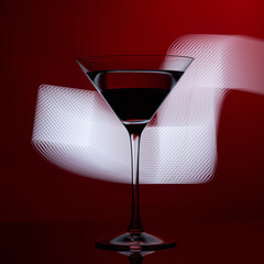Martini glass on a red background with white lights.