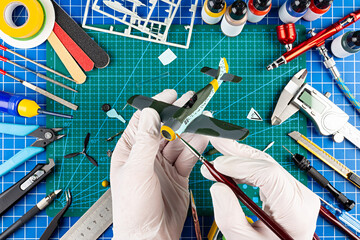 desktop view from above of assembly and painting of retro scale model fighter plane concept...