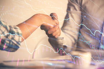 Fototapeta premium Double exposure of forex graph hologram and handshake of two men. Stock market concept.