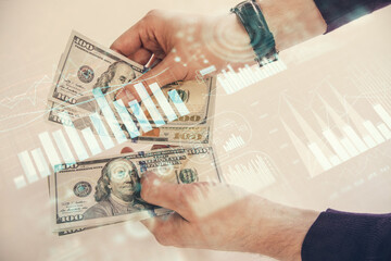 Multi exposure of financial graph drawing hologram and USA dollars bills and man hands. Analysis concept.