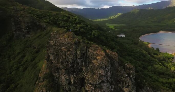 Panning aerial, hiker on O'ahu Island mountains