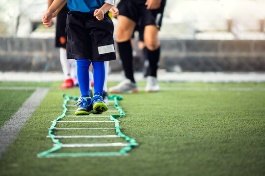 Kid soccer player Jogging and jump between marker for football training. Ladder Drills Exercises for Football team. Kid player exercises on ladder drills. - Powered by Adobe