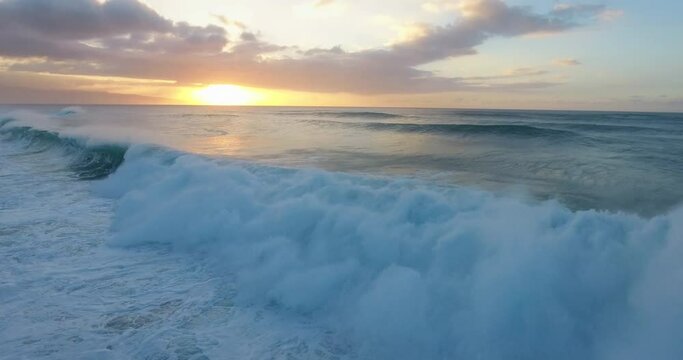 Wide aerial, sunset over ocean waves in Hawaii