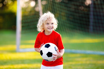 Kids play football. Child at soccer field.