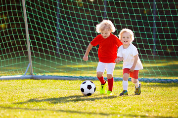 Kids play football. Child at soccer field.