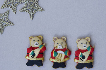 Christmas decoration: felt bears, musicians, stars. Grey background. Top view