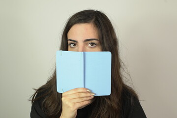 woman holding a blank book infront of her face