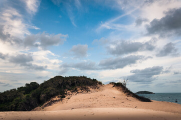 Landscape of the Santinho's dune near the beach of Praia dos ingleses on a beautiful sunny day with a big blue sky and clouds.