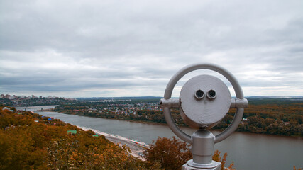 binoculars on the observation deck.mountain view of the city and autumn forest.