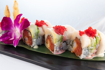 Artistic sushi roll with spicy tuna and deep fried crab meat delicately presented on a plate to eat