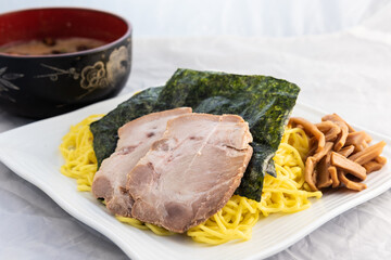 Tsuke ramen, sea weed, broth bowl, with pork delicately presented on a plate to eat