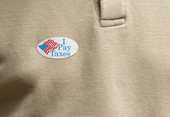 I Pay Taxes sticker on mans T-shirt for anger about the lack of federal tax paid by president in...