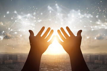 Obraz premium Technology concept: Silhouette many people raised hands over city sunset background
