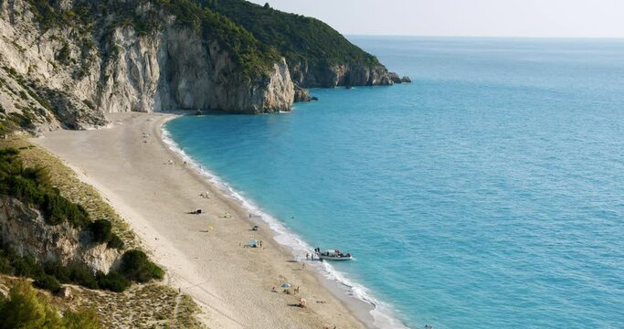 Milos beach in evening summer light, Lefkas, Greece. Hop on boats pick up the tourists