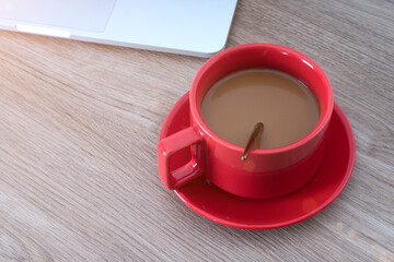 Looking down shot a cup of coffee and a laptop on the table