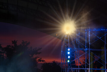 The lights from the lamps on the steel columns of the concert stage