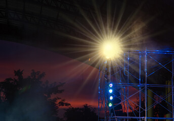 The lights from the lamps on the steel columns of the concert stage
