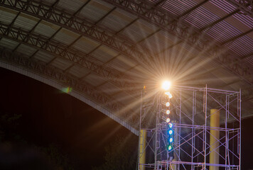 
The lights from the lamps on the steel columns of the concert stage