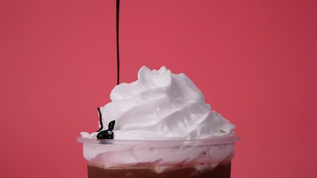 Pour chocolate whipped cream on pink background, Food concept Front view.