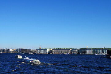 Fototapeta na wymiar St. Petersburg view from the Neva River to the embankment along the Hermitage, along the river floats a meteor, a clear blue sky with a copy space