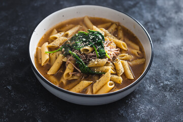 plant-based food, vegan penne pasta with broth and spinach and mushroom topping