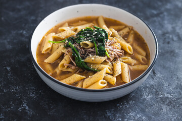 plant-based food, vegan penne pasta with broth and spinach and mushroom topping
